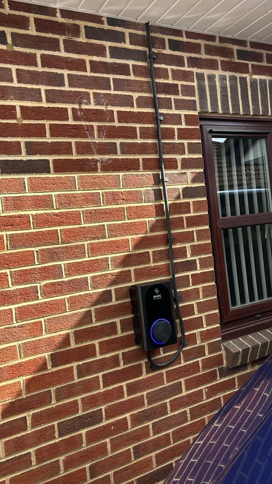Wall-mounted EV charger on brick exterior